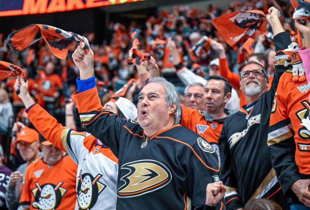 Ducks fans wave towels in the air as they chant...