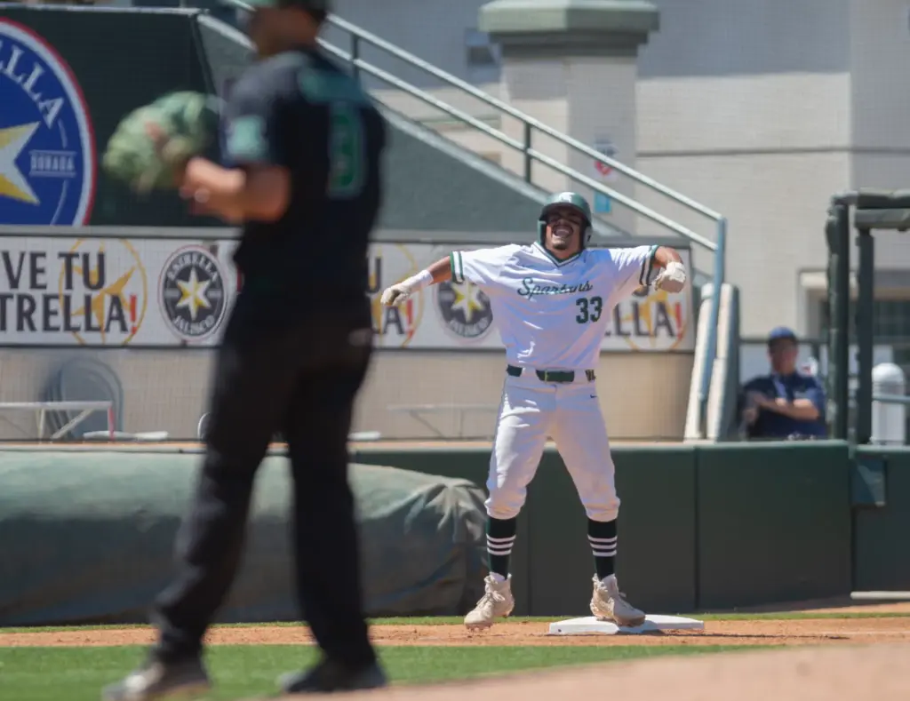 Schurrâs Javon Bryant, (#33), celebrates at third base after hitting...