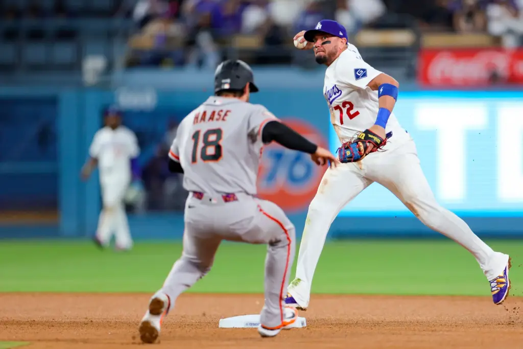 Dodgers shortstop Miguel Rojas, right, attempts to throw out the...