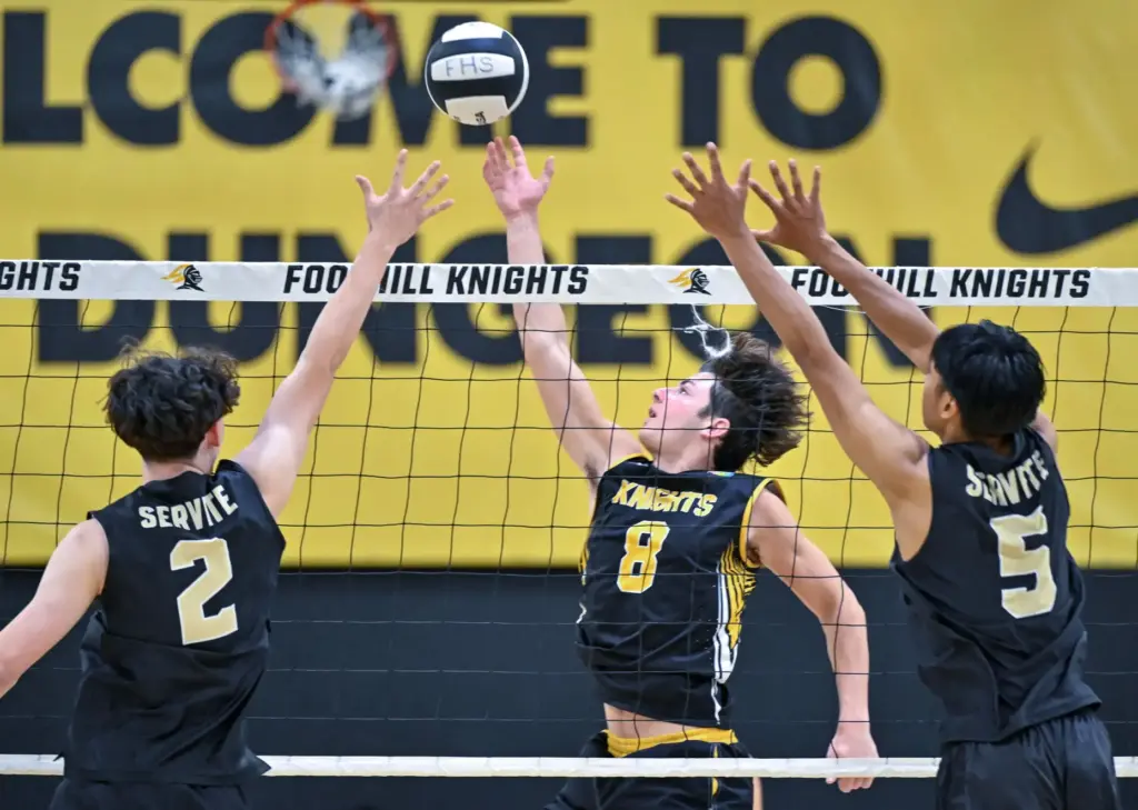 Foothill middle blocker Ethan Fernandez tips the ball over Servite...