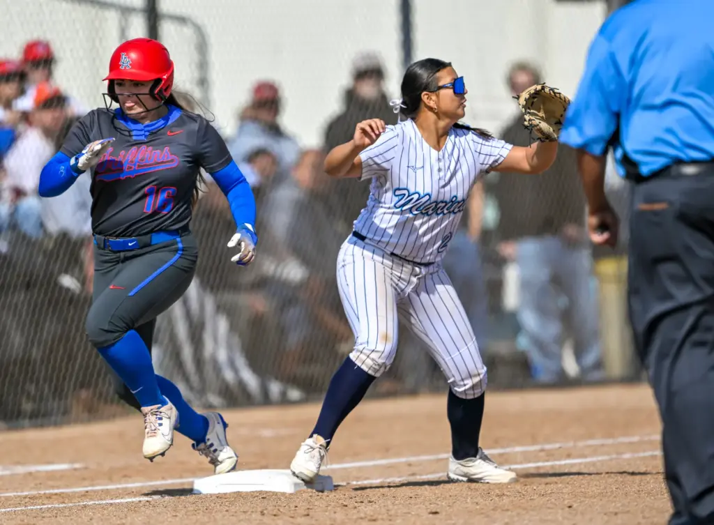 Los Alamitos outfielder Erin Denny gets safely to first base...