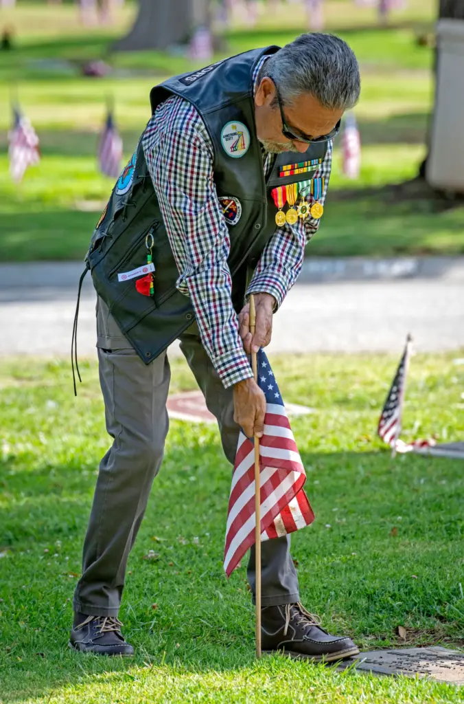 Vietnam War veteran Porfirio Duarte puts a flag into the...