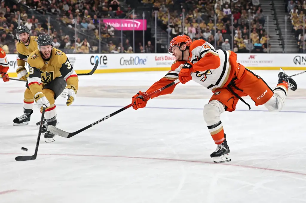 The Ducks’ Beckett Sennecke, right, shoots the puck as the...