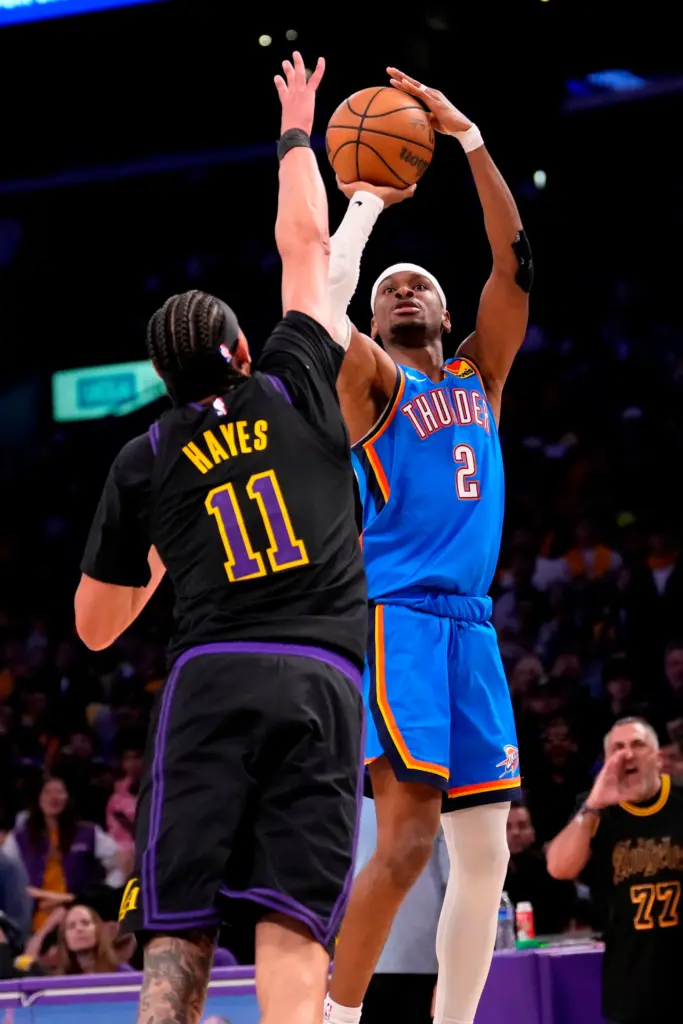 Oklahoma City Thunder guard Shai Gilgeous-Alexander, right, shoots as Lakers...