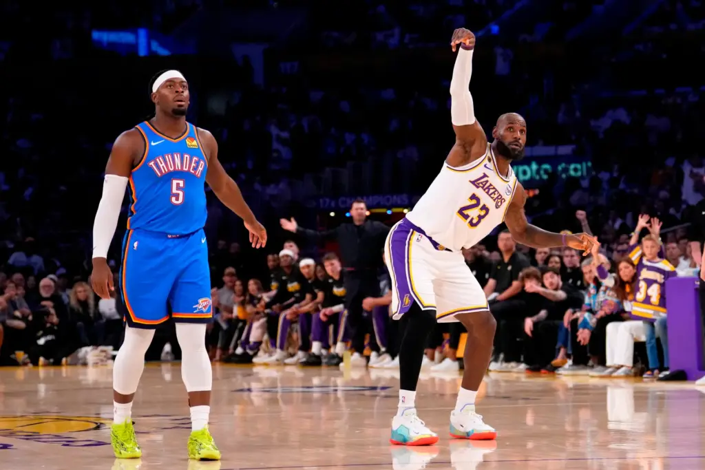 Lakers forward LeBron James, right, watches along with Oklahoma City...