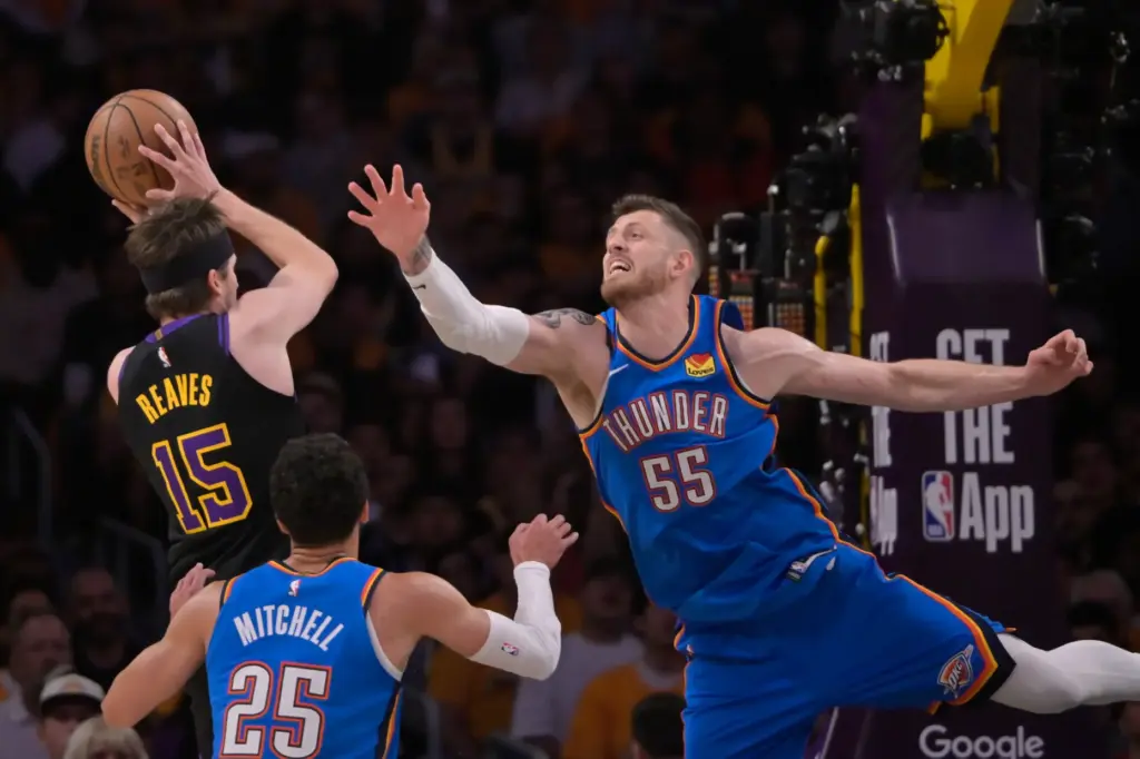 Lakers guard Austin Reaves, left, takes a shot as Oklahoma...