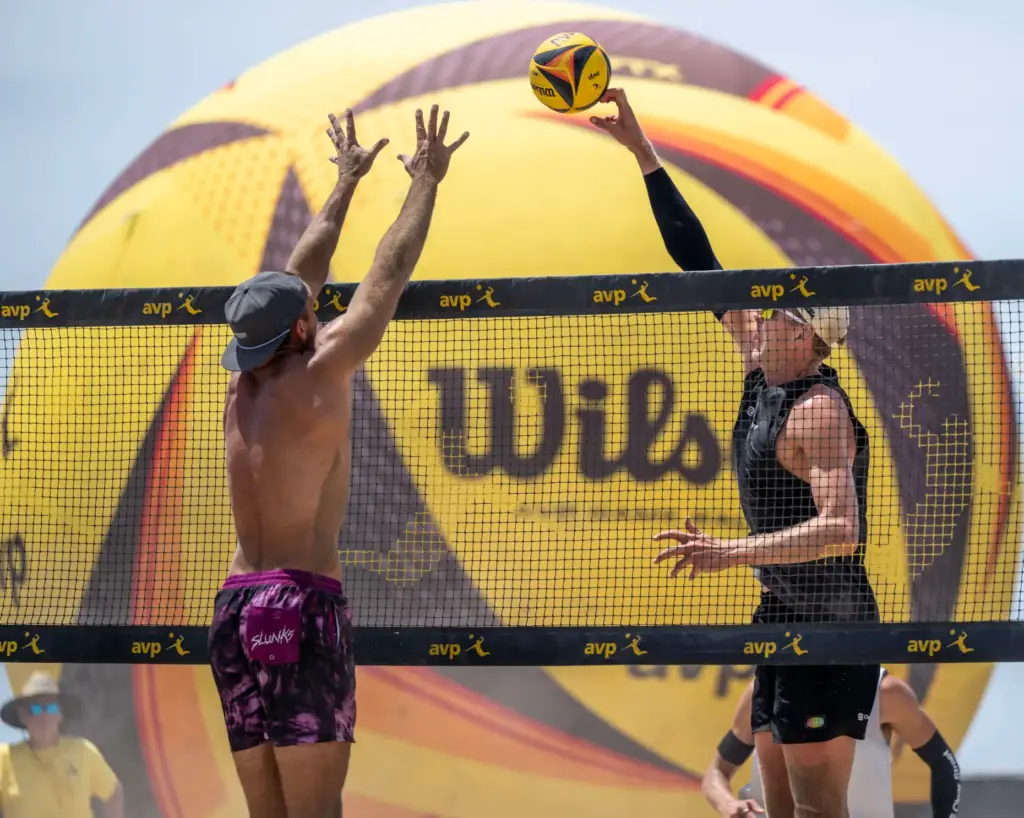 James Shaw, right, hits the ball past the block of...