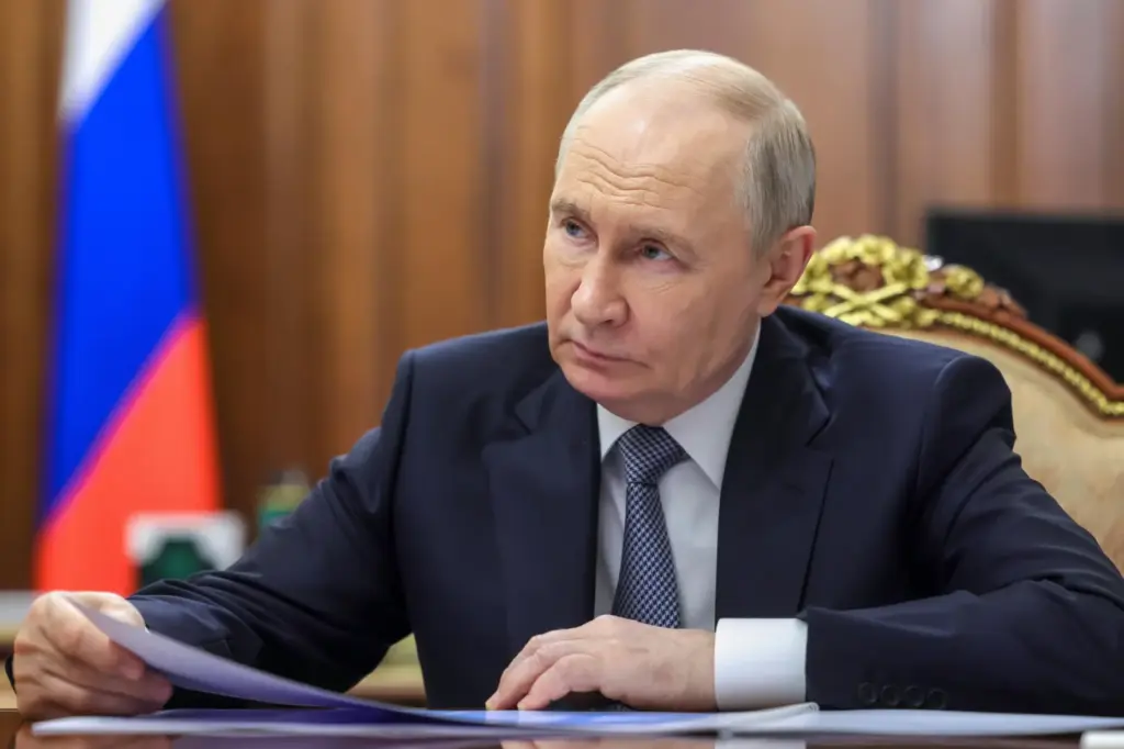 Russian President Vladimir Putin listens to Minister of Economic Development...