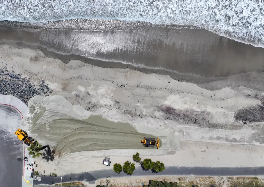 The first of 13,500 cubic yards of sand is delivered...