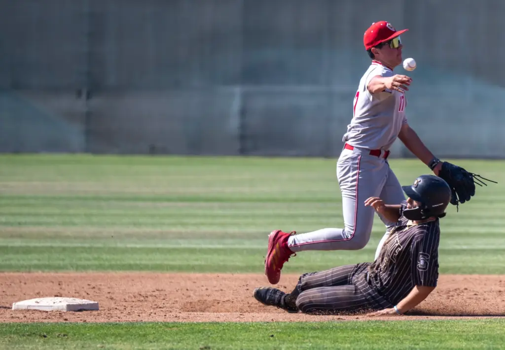 Orange Lutheran shortstop Zion Avina tags out Serviteâs PJ Becerra...