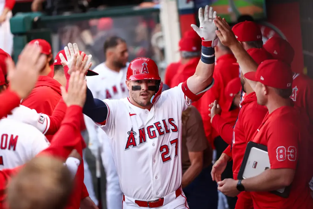 Angels star Mike Trout celebrates in the dugout after hitting...