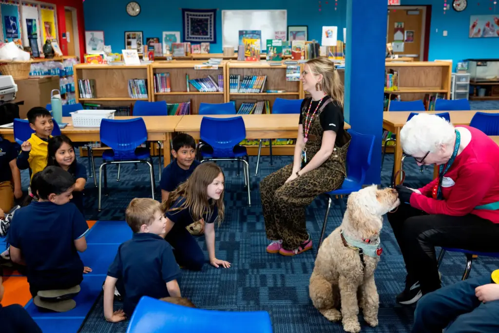 School social worker Nicole Herje, center, therapy dog Sage and...