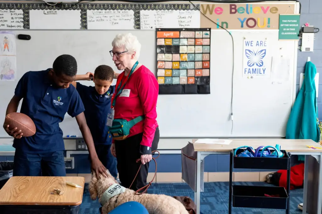 Shane Jackson, left, pets Sage, a therapy dog, while chatting...