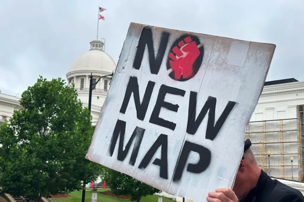 A demonstrator holds up a sign outside the Alabama Statehouse.