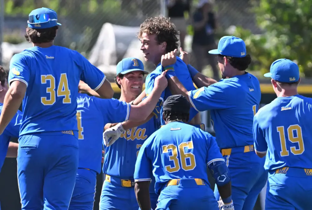 UCLA’s Phoenix Call, center, is mobbed by his teammates after...
