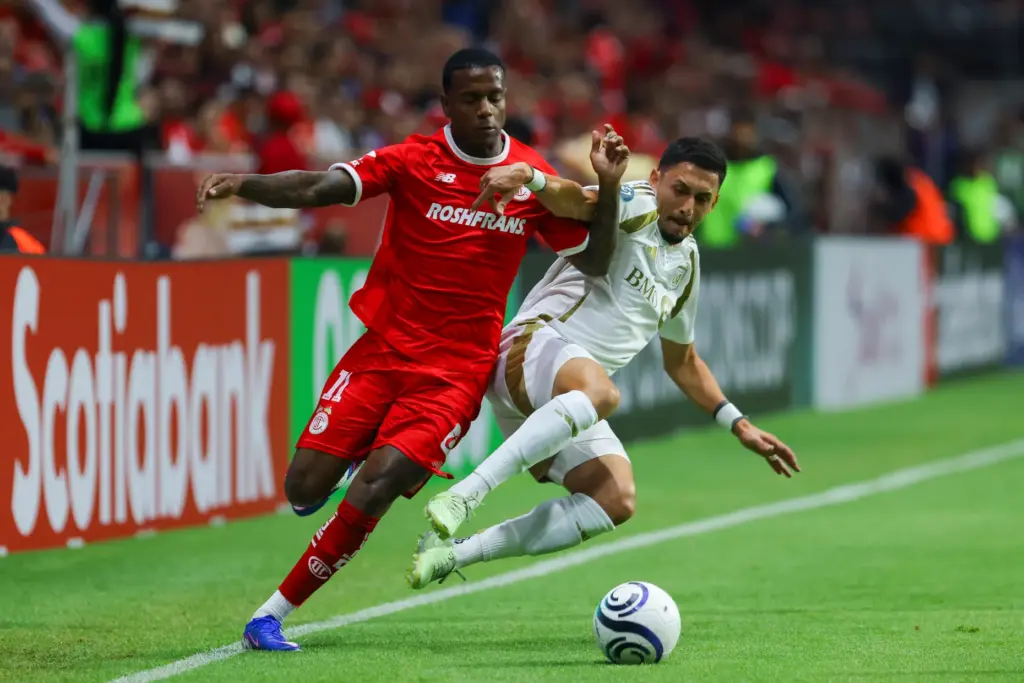 Toluca FC’s Helio Nunes, left, battles for the ball with...