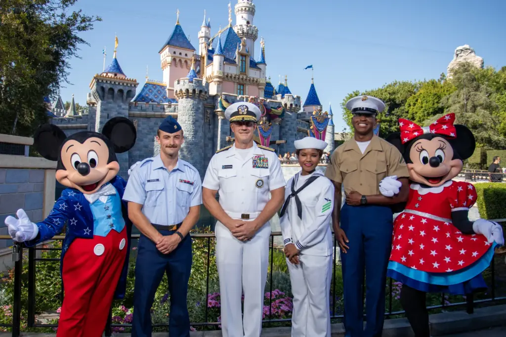 U.S. Sailors, Marines and Coast Guardsmen pose with Mickey Mouse...