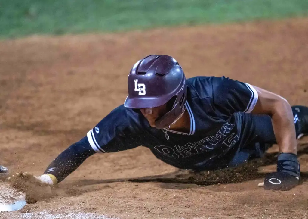Laguna Beach outfielder Otis Boultinghouse dives safely back to first...