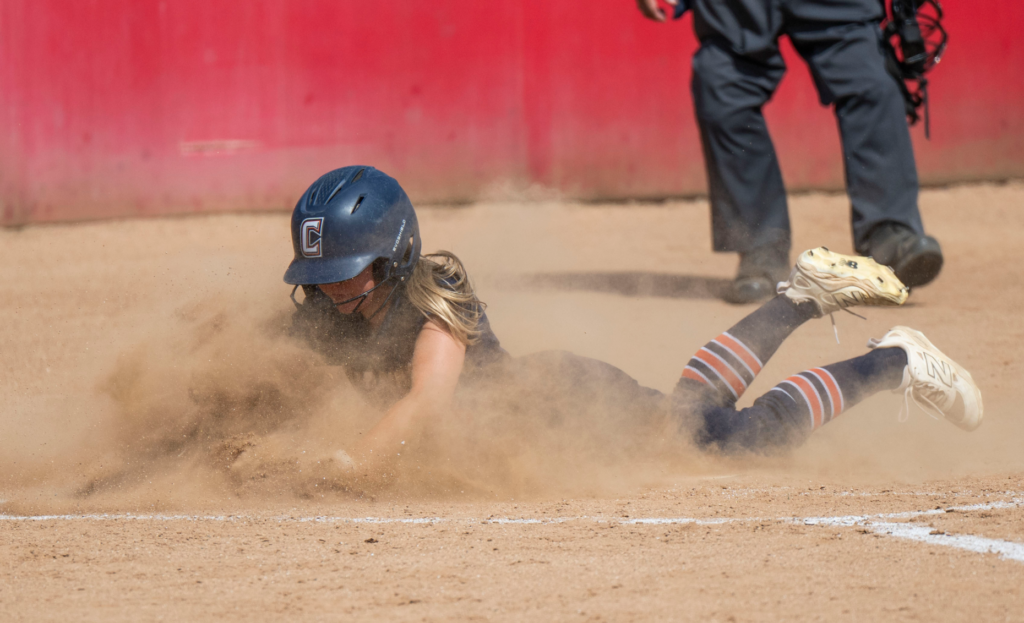 Cypress’ Cameron Gill slides into home to score a run...