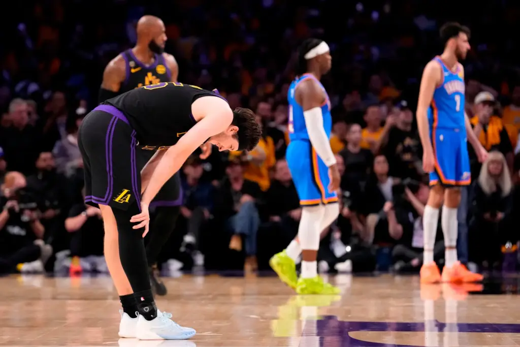 Lakers guard Austin Reaves, left, reacts after missing a 3-point...