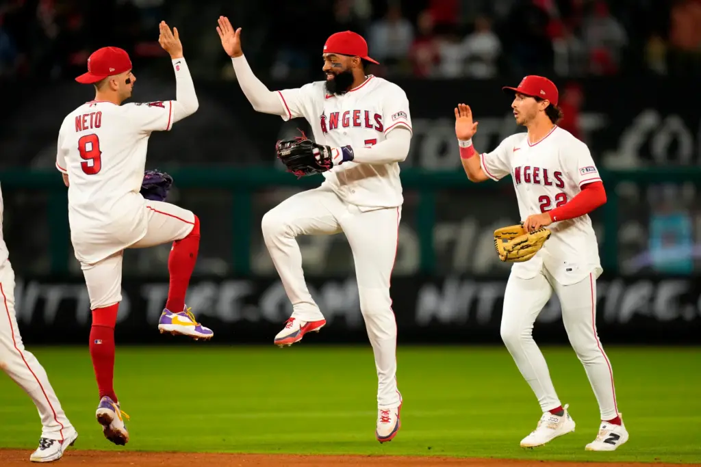 Angels shortstop Zach Neto, left, right fielder Jo Adell, center,...