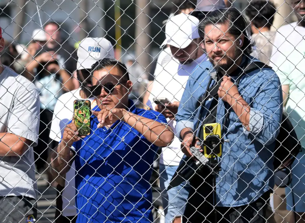 Race fans catch a glimpse of race cars in a...