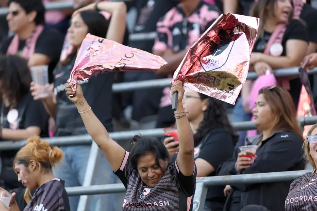 An Angel City FC fan waves a pair of flags...