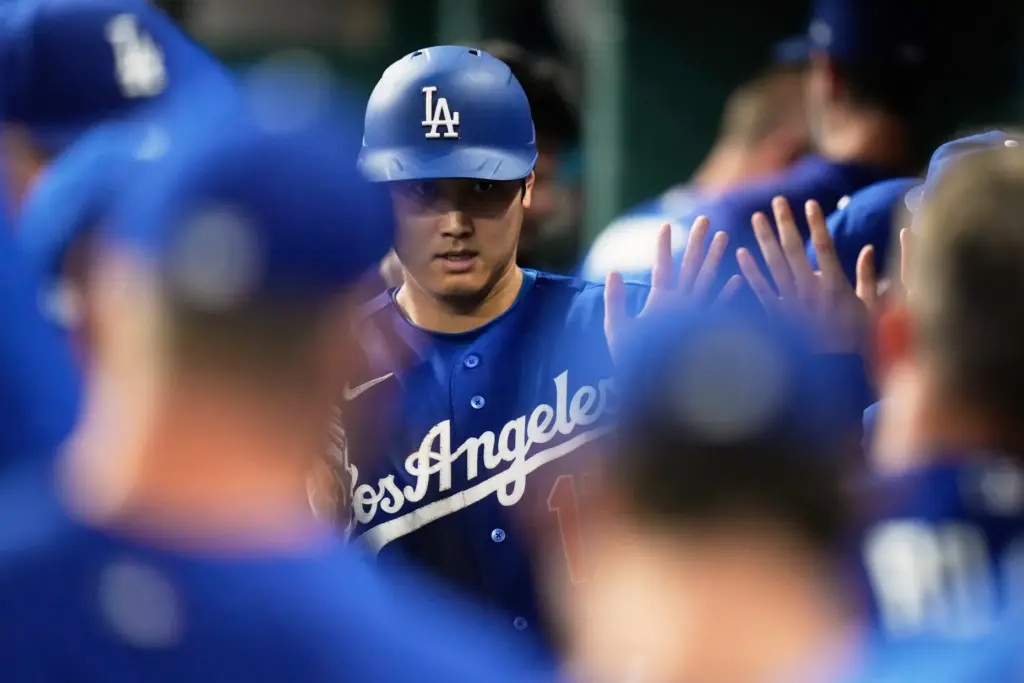 Dodgers designated hitter Shohei Ohtani celebrates in the dugout after...