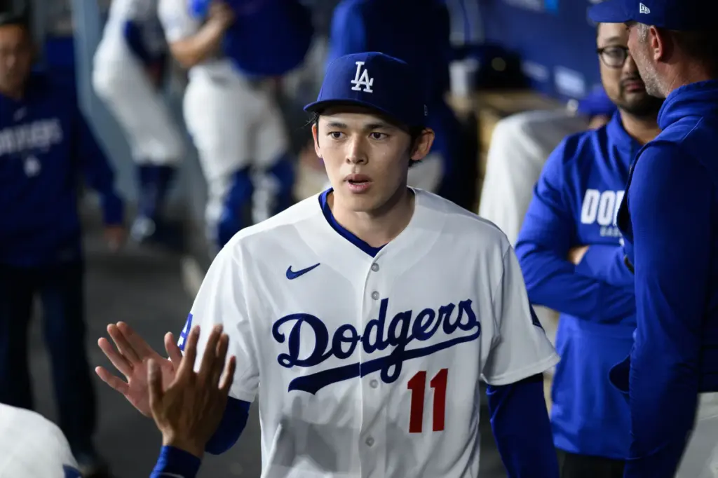 Dodgers starting pitcher Roki Sasaki is greeted in the dugout...