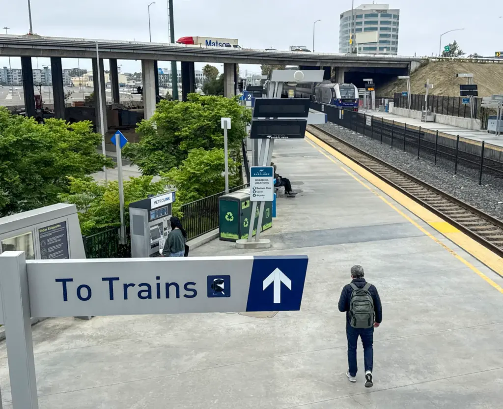 A northbound Metrolink train leaves ARTIC as people wait for...