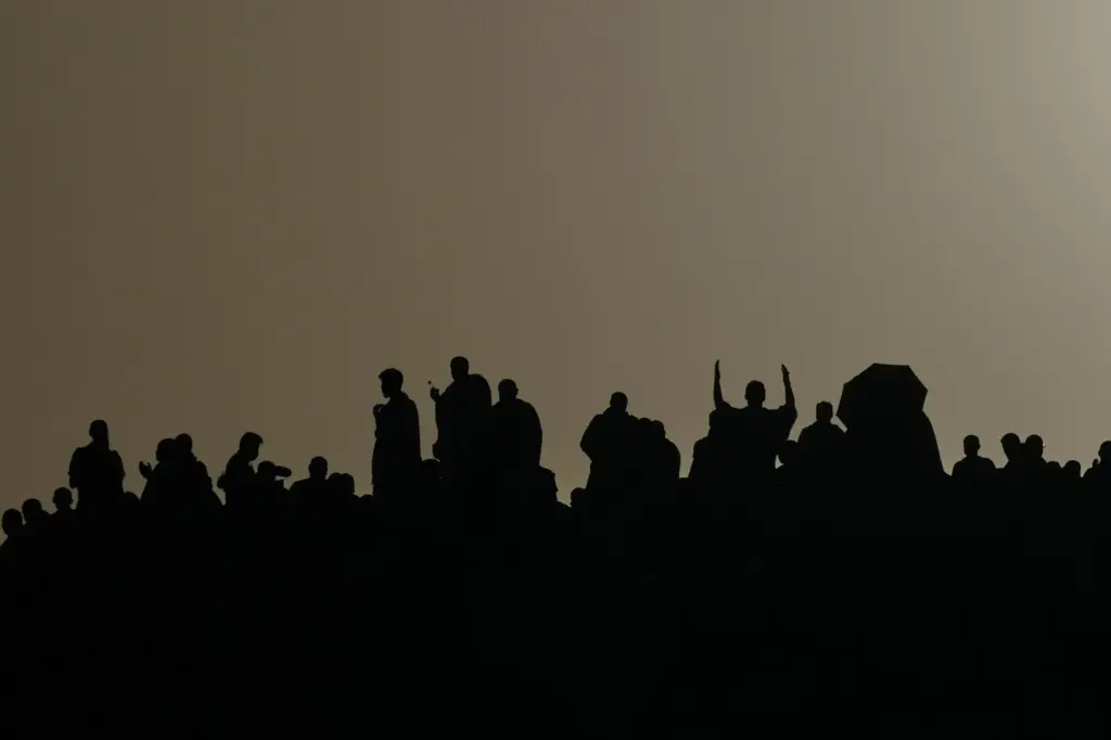 Muslim pilgrims are silhouetted as they pray