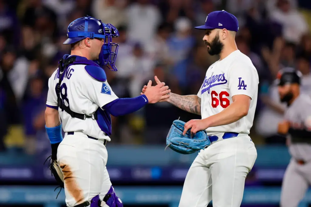 Dodgers relief pitcher Tanner Scott, right, greets catcher Dalton Rushing...