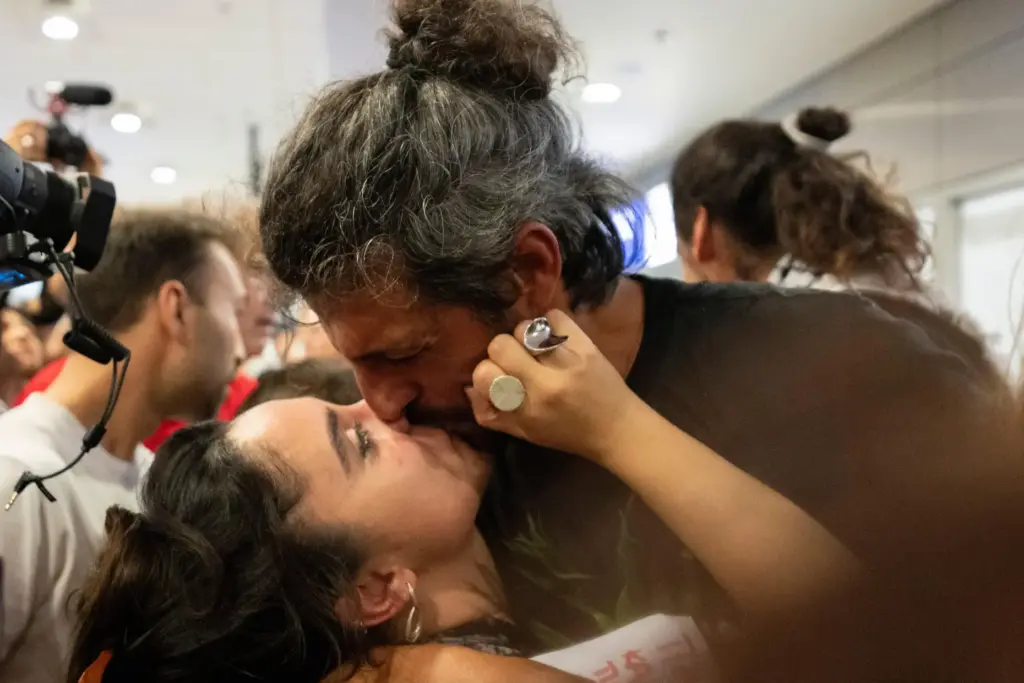 An activist from the Global Sumud Flotilla kisses a woman...