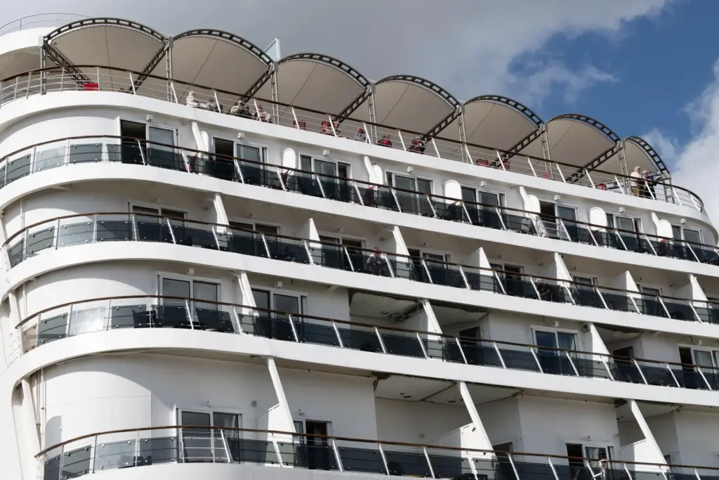 Passengers stand aboard the British cruise ship Ambition, as French...