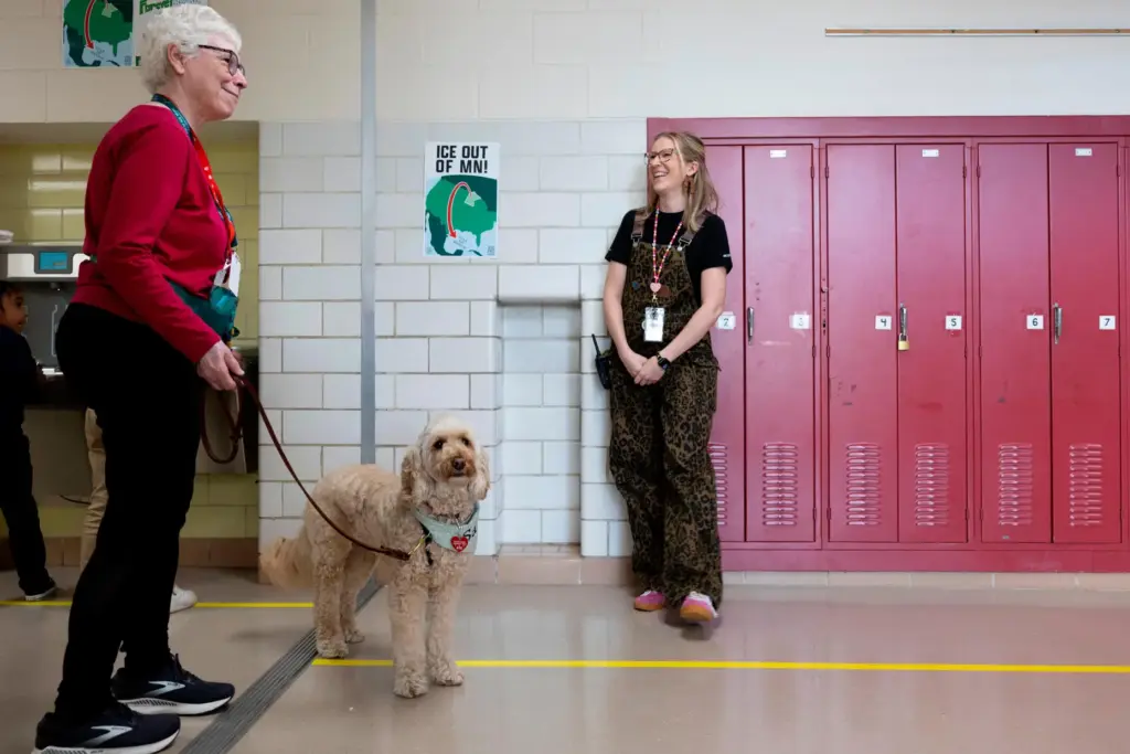 Linda Buchs-Hammonds, left, and her therapy dog, Sage, walk through...