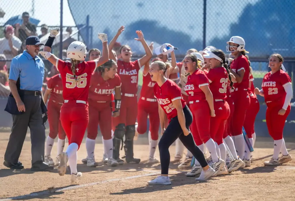Orange Lutheran players celebrate a home run by infielder Carlie...