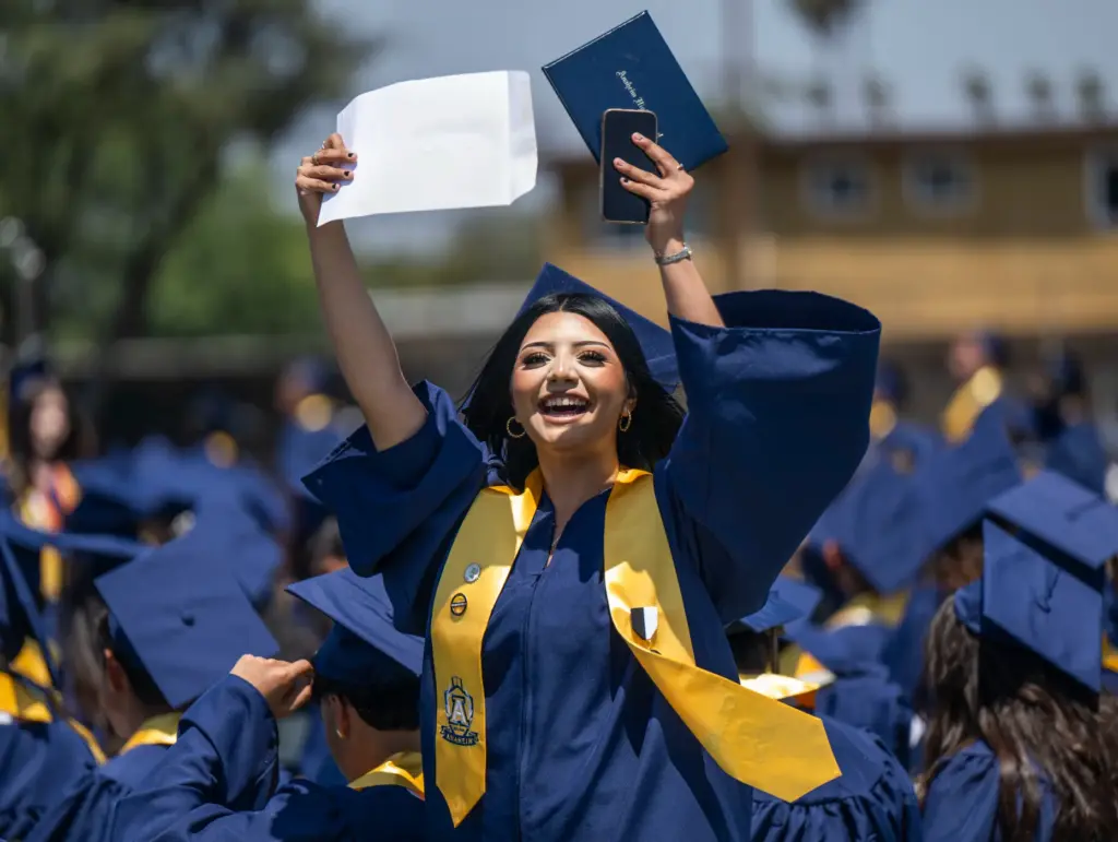 A proud Yahaira Sandoval waves her diploma in the air...