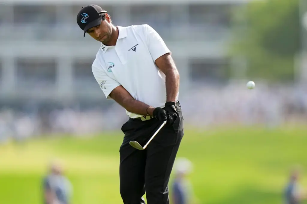 Aaron Rai, of England, chips onto the 18th green during...