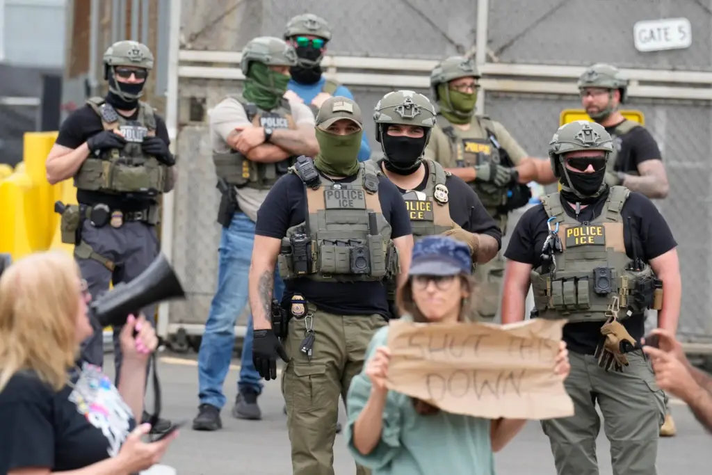 Masked federal agents stand outside the Delaney Hall detention center...