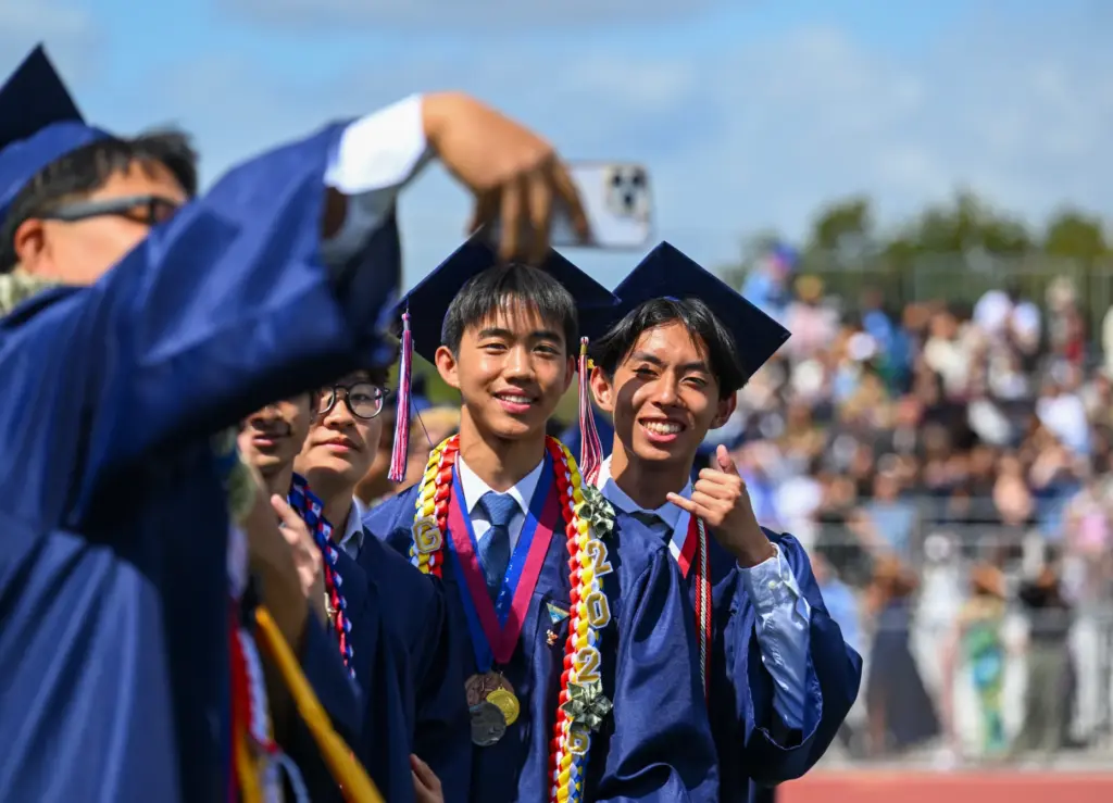 Quayle Chen takes a picture of fellow graduates Anthony Low,...