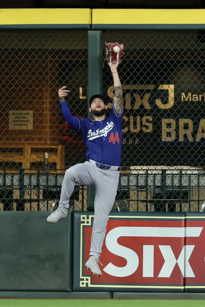 Dodgers center fielder Andy Pages leaps to catch a fly...