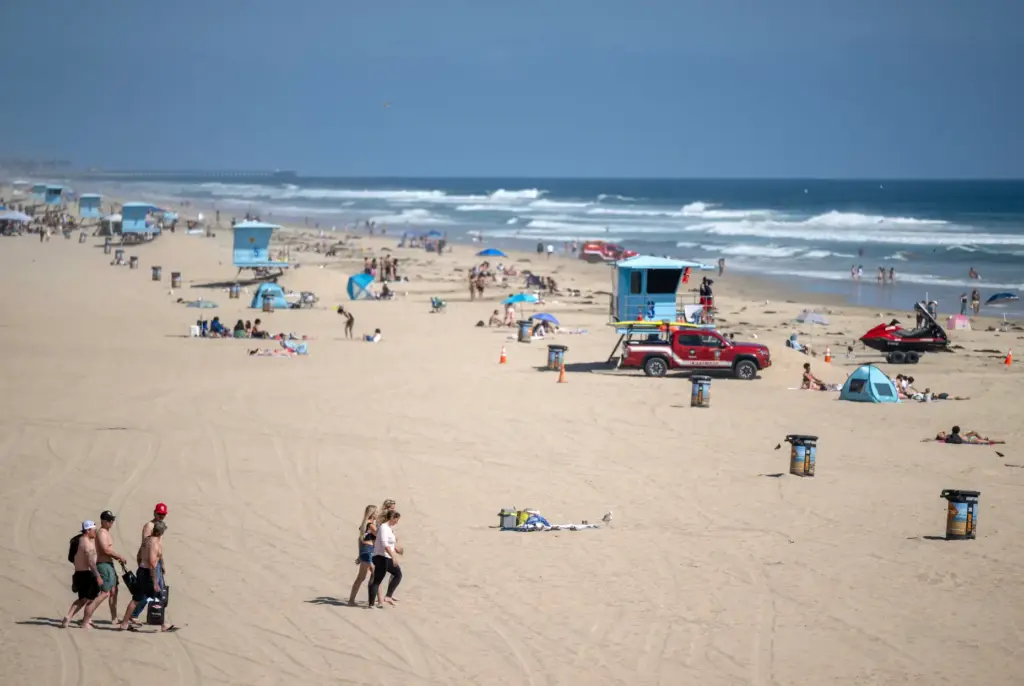 Beachgoers make their way onto the sand just south of...