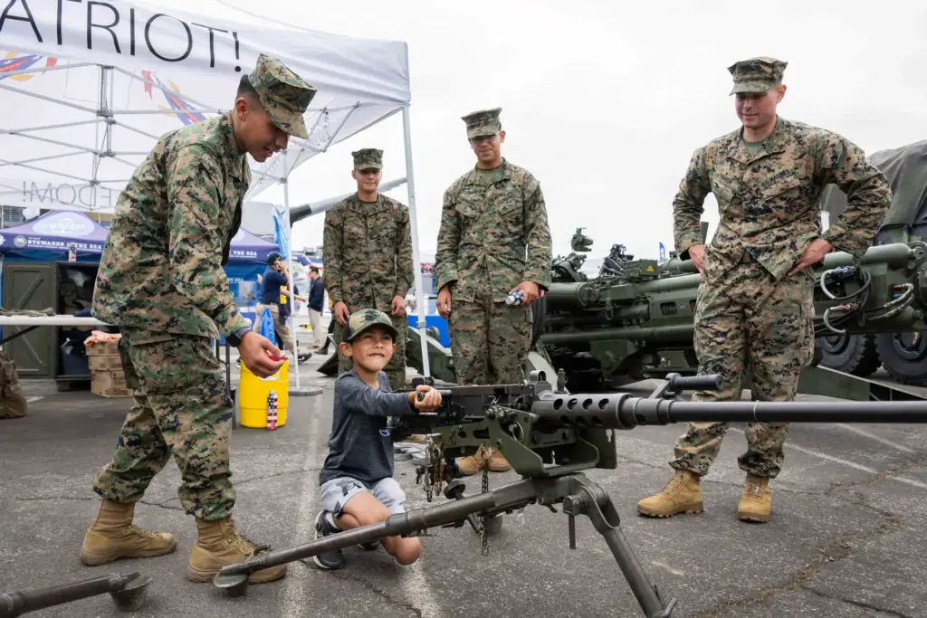 Seven-year-old Roman Ruiz poses for a photograph with an M2A1...