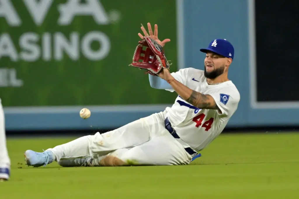 Dodgers center fielder Andy Pages slides as he makes a...