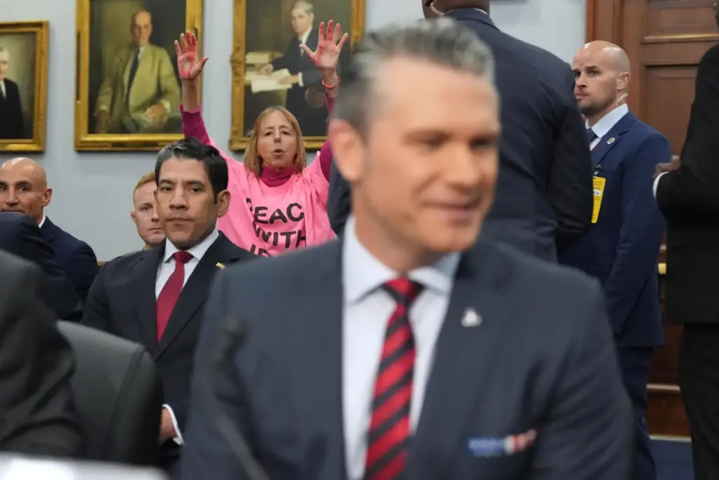 A protester interrupts as Defense Secretary Pete Hegseth arrives to testify.