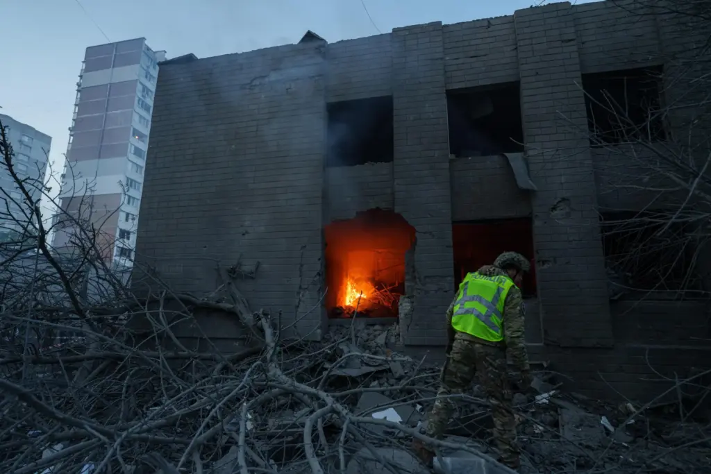 A policeman look at a building damaged after a Russian strike in Kyiv.