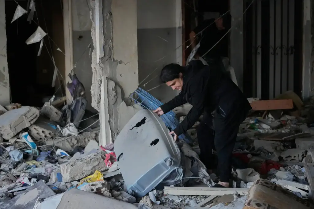 A woman checks a destroyed apartment that was hit in an Israeli airstrike.