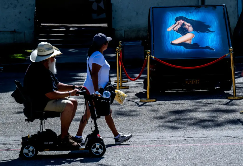 Fair goers enjoy art work on lowriders on display by...