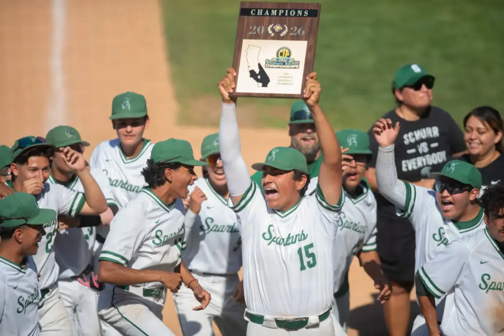 Schurrâs Isaiah Trevino, (#15), holds up the championship plaque and...