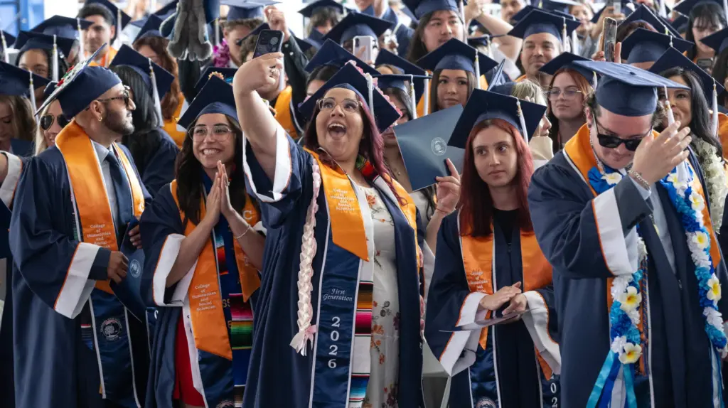 Students do the ceremonial tassel move — from the right...